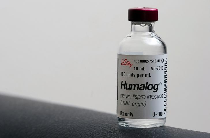 A small glass vial filled with a clear liquid and labeled as Humalog insulin