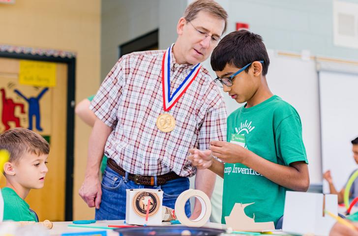 Peter Wurman listens to a Camp Invention camper describing their invention idea
