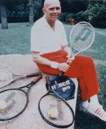 Howard Head sitting with tennis rackets