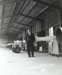 Kaplan in hangar with missles or rockets.