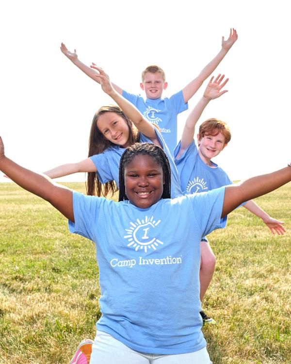 Camp Invention campers stand in a line and raise their arms in different directions