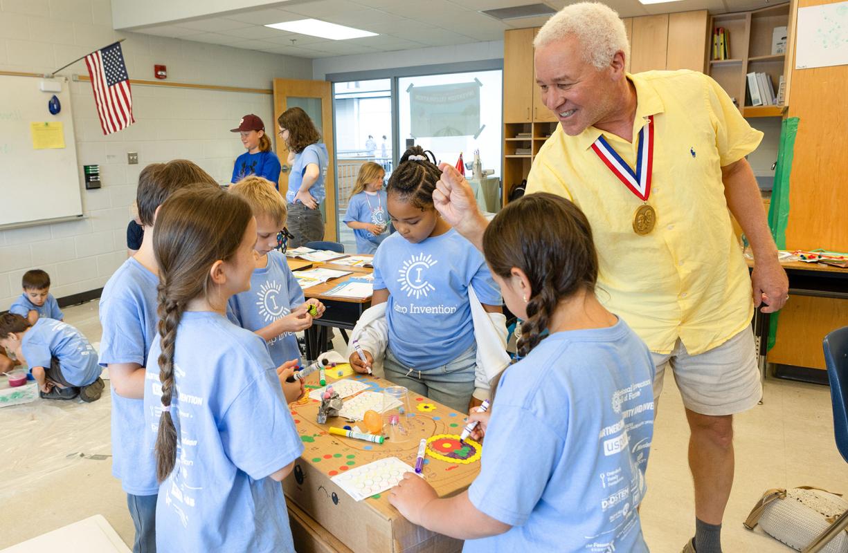 Inductee Robert Bryant encourages a group of elementary students as they work together to design an invention prototype