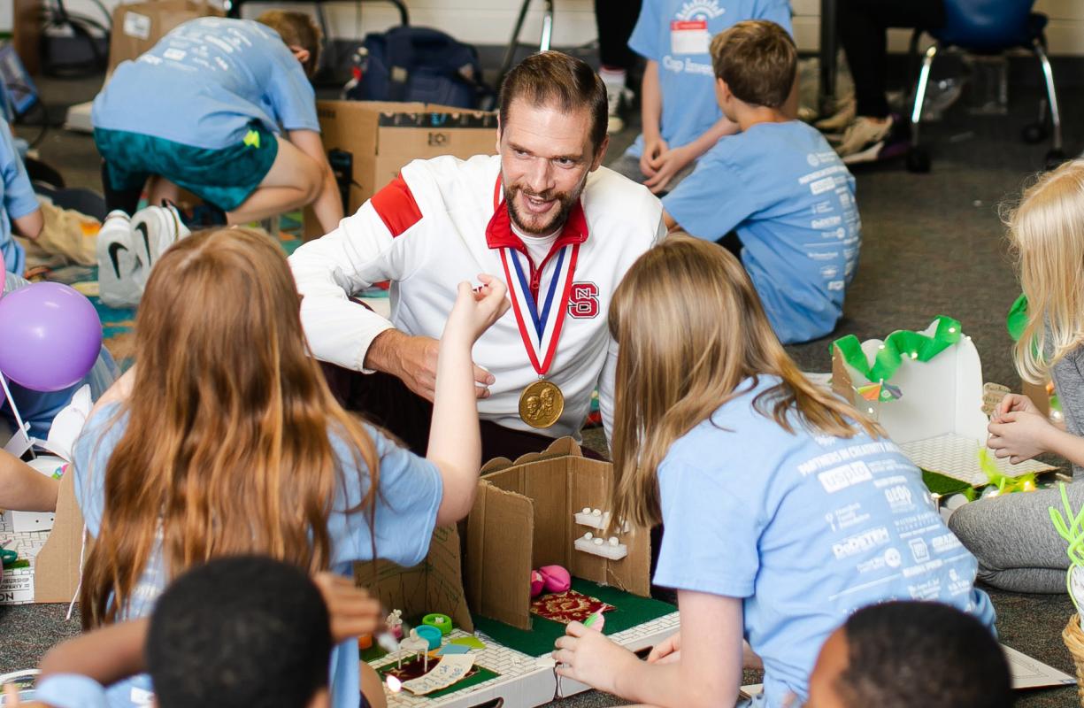 Inductee Rodolphe Barrangou listens as a Camp Invention camper explains their invention idea