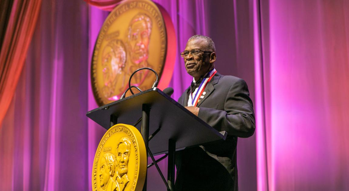 Lonnie Johnson speaking on stage at induction ceremony