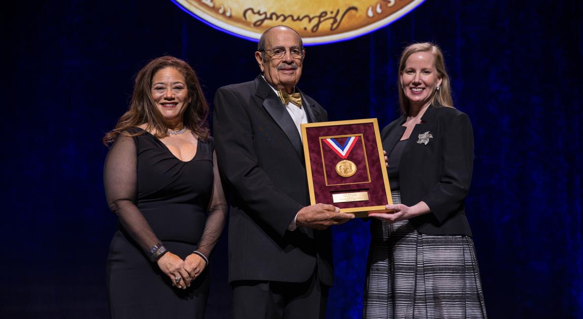 A representative receives the National Inventors Hall of Fame medal for a historical Inductee